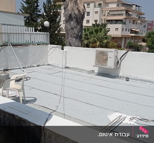 גג עם יריעות איטום, כיסא פלסטיק ומיכל גז